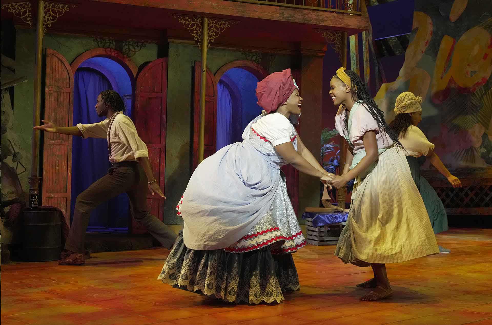 Two people looking at each other, smiling and holding hands.