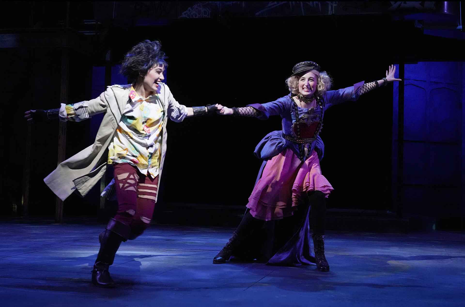 Two women running and holding hands.