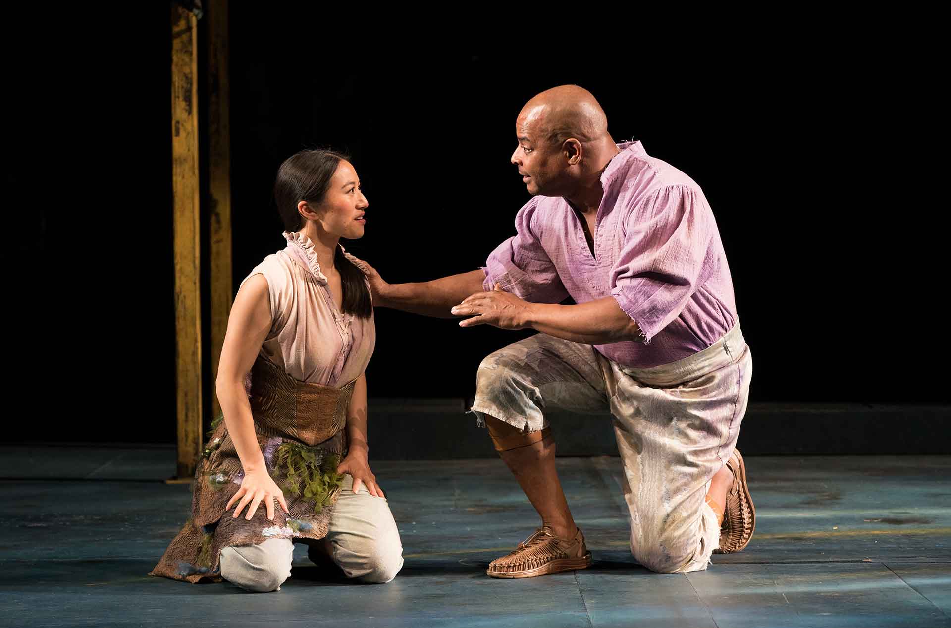 Woman sitting on knees talking to an older man kneeling beside her.
