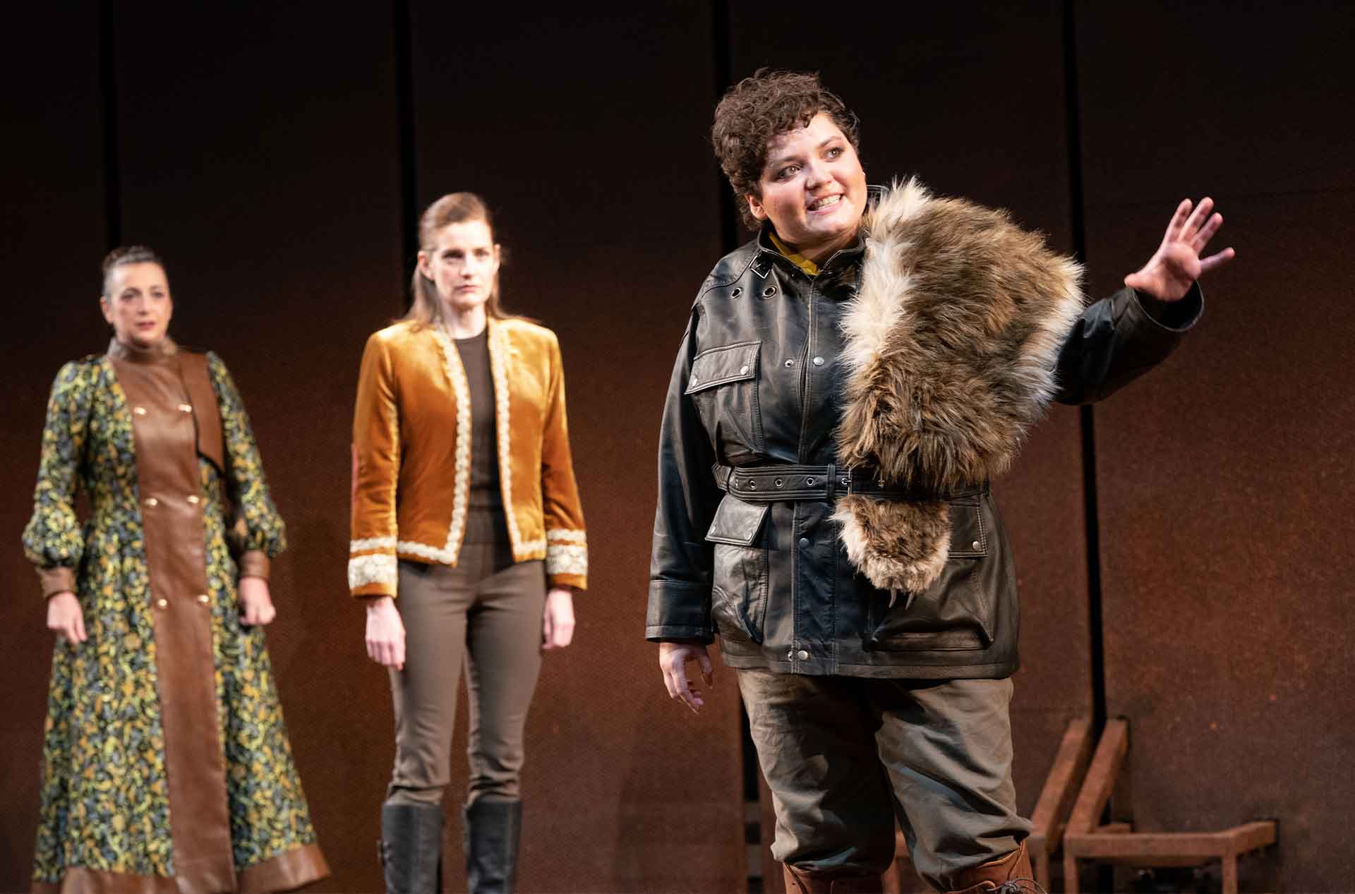 Two people standing behind and looking at another person looking into the distance.