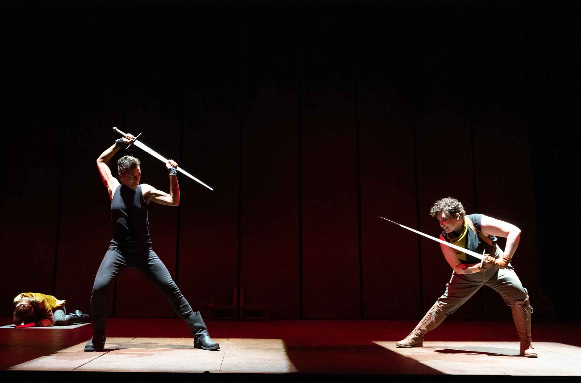 Two people pointing swords at each other.