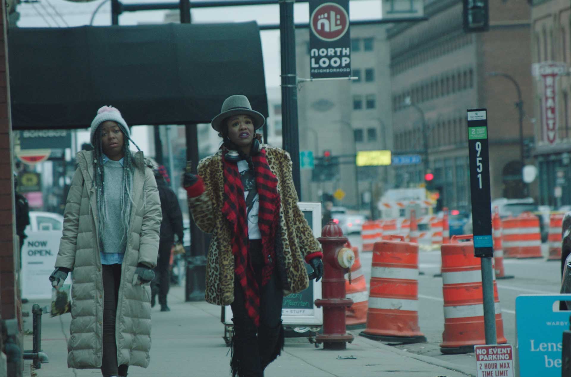 Two people walking down a sidewalk.