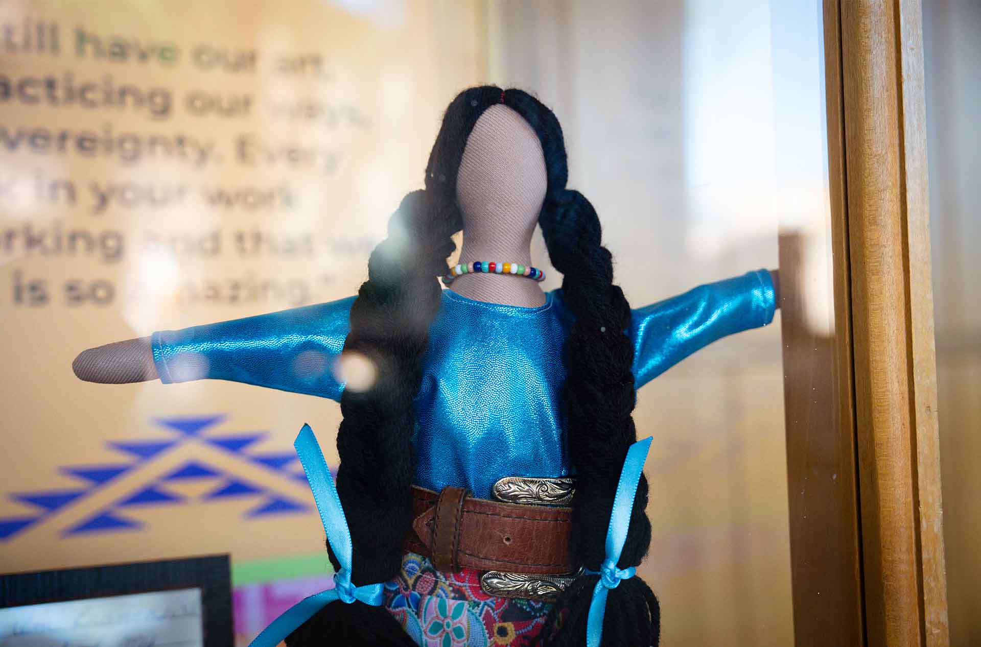 A doll inside a glass display case.