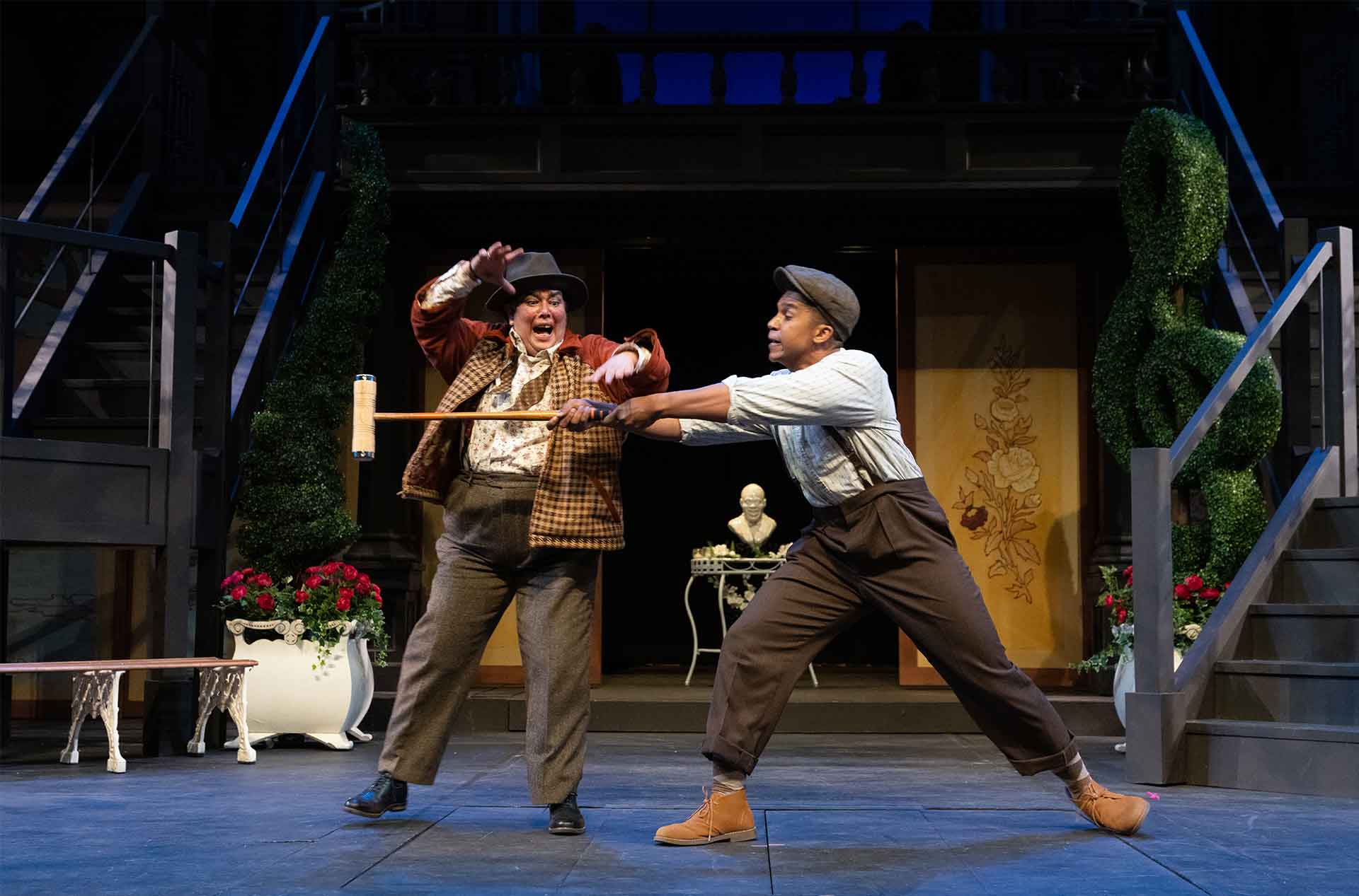 Two people fighting with a croquet mallet.