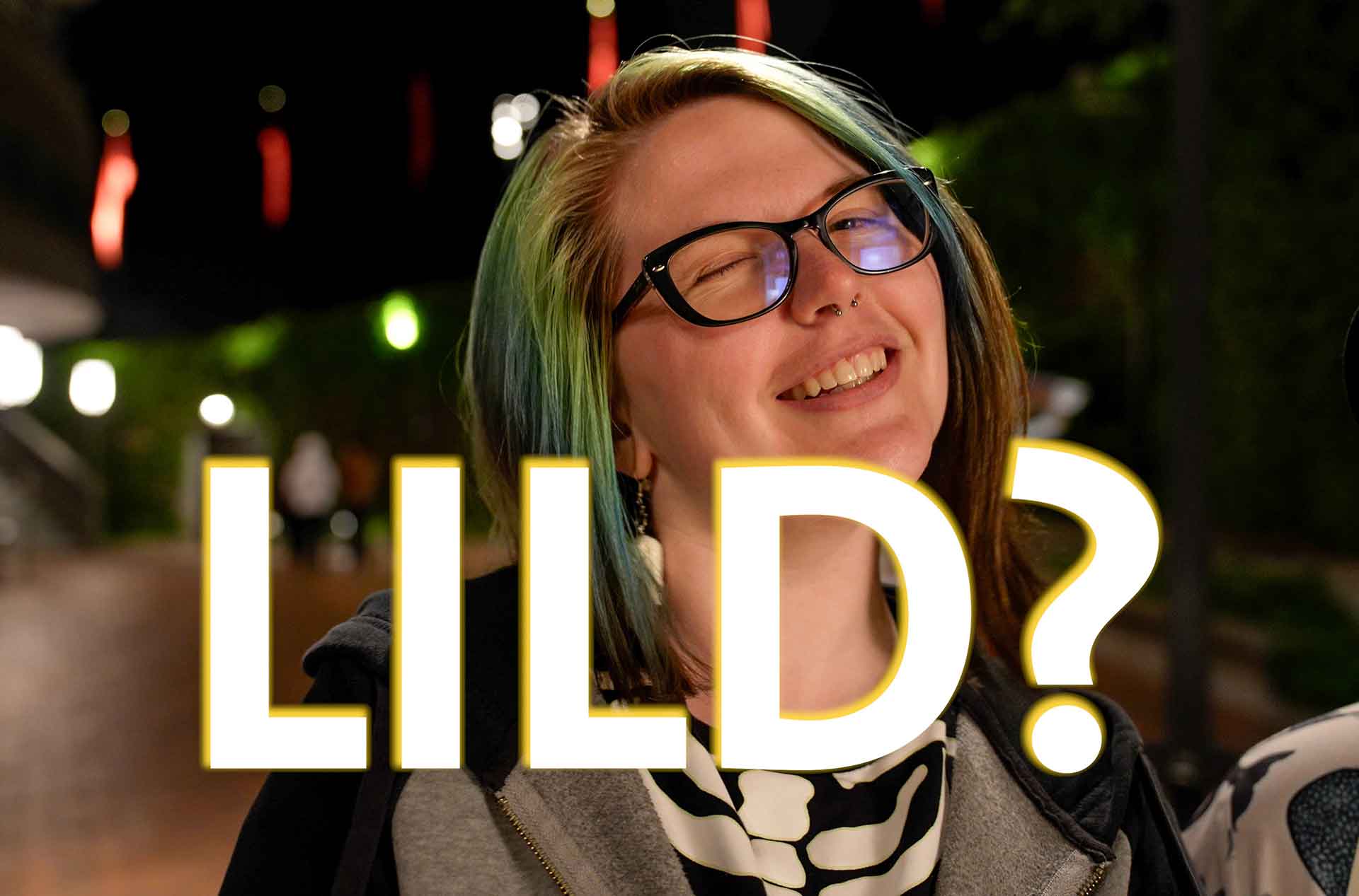 Person wearing glasses smiling at the camera.