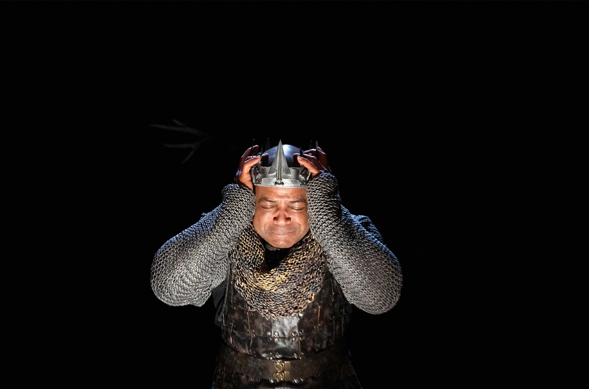 A king holding the crown on his head in dispare. 