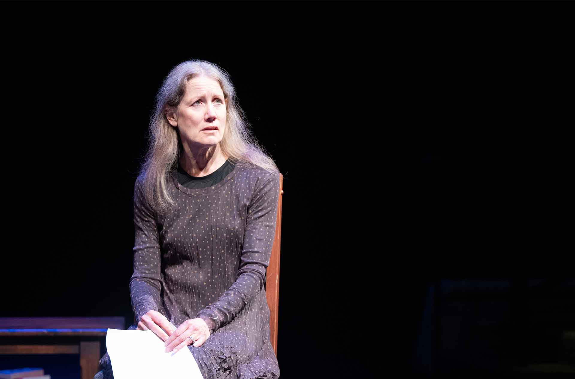 A woman sitting holding a paper.
