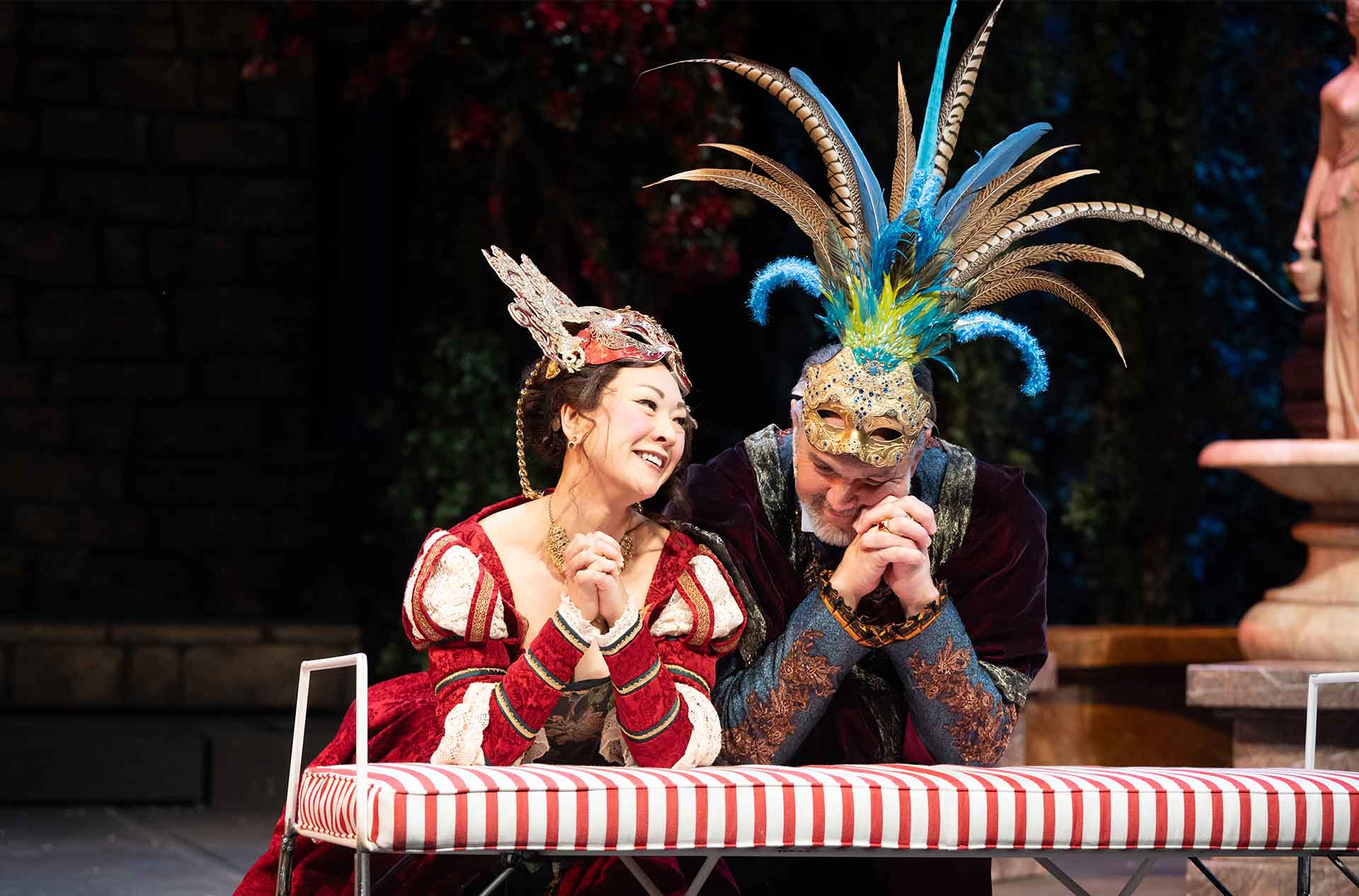 Two people kneeling with their elbows on a bench.