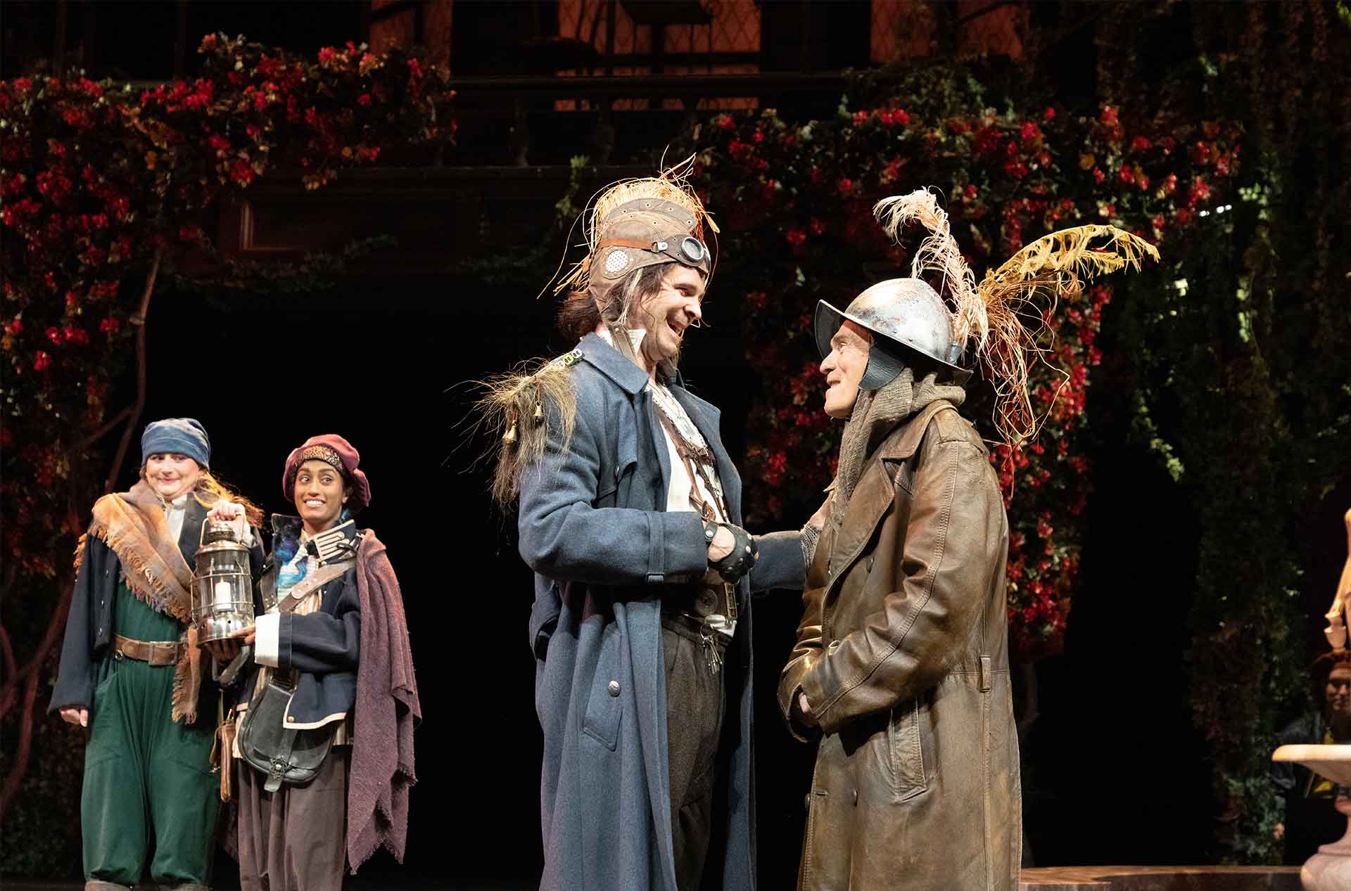 Two people in large hats standing in the foreground facing each other.