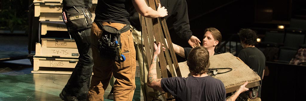 A group of people carrying a prop.